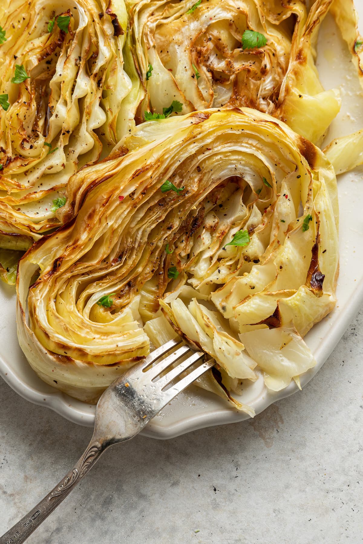 Roasted cabbage pulled apart with a fork.