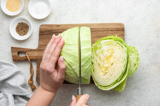 Cutting a cabbage into 1 inch thick slices.