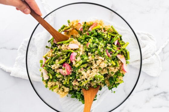 Mixing together salad ingredients.