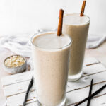 Two protein shakes with cinnamon sticks.