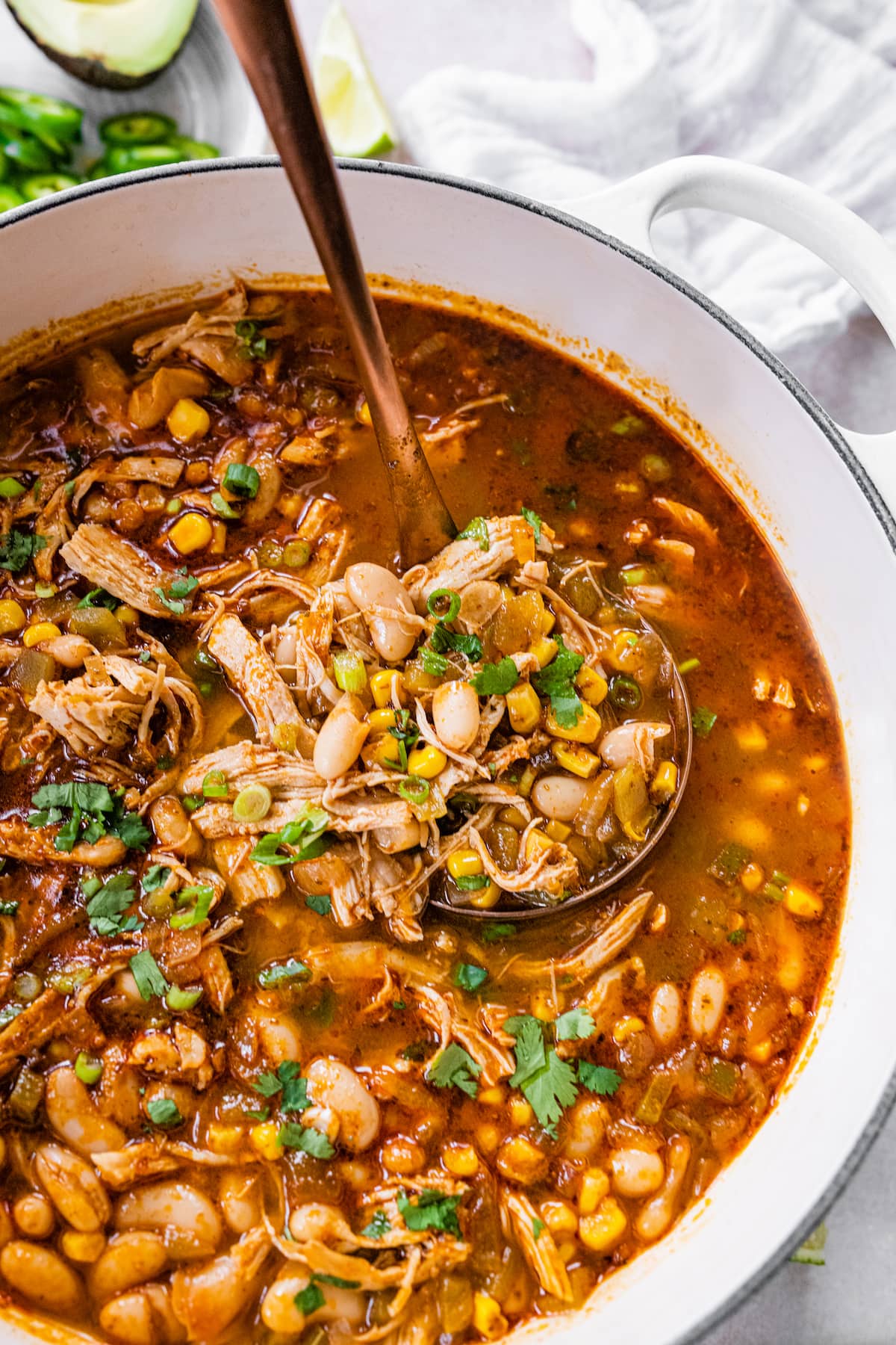 A pot of white bean chicken chili with a serving ladle.