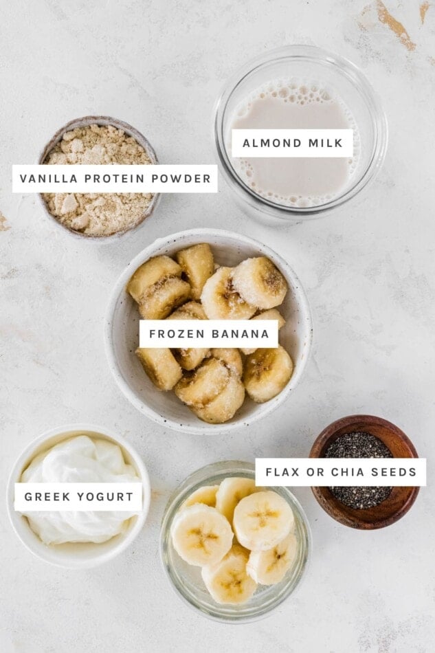 Greek yogurt, almond milk, frozen banana, flax seed and vanilla protein powder measured out.