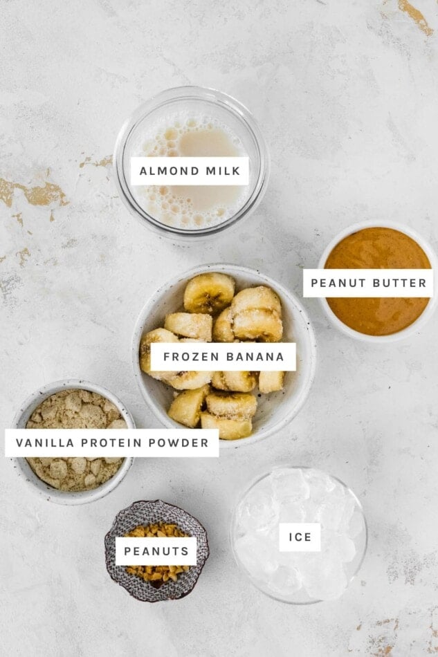 Almond milk, peanut butter, frozen banana and vanilla protein powder measured out.