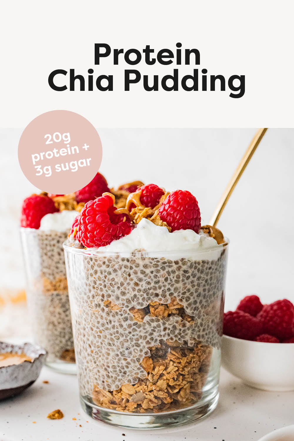 Jar of protein chia pudding layered with granola and topped with berries, nut butter and coconut whip.