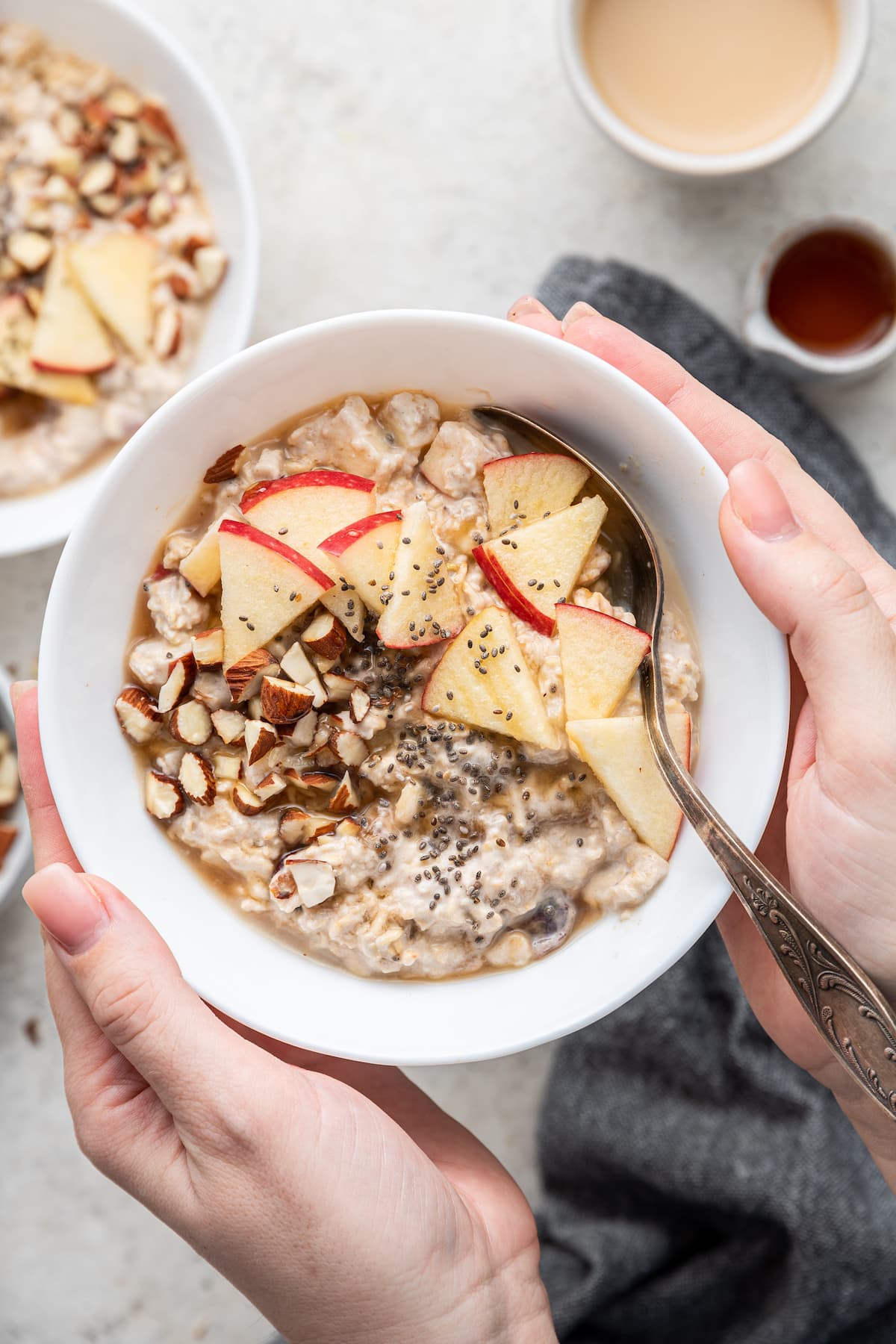 Woman's hands holding a bowl of bircher muesli.