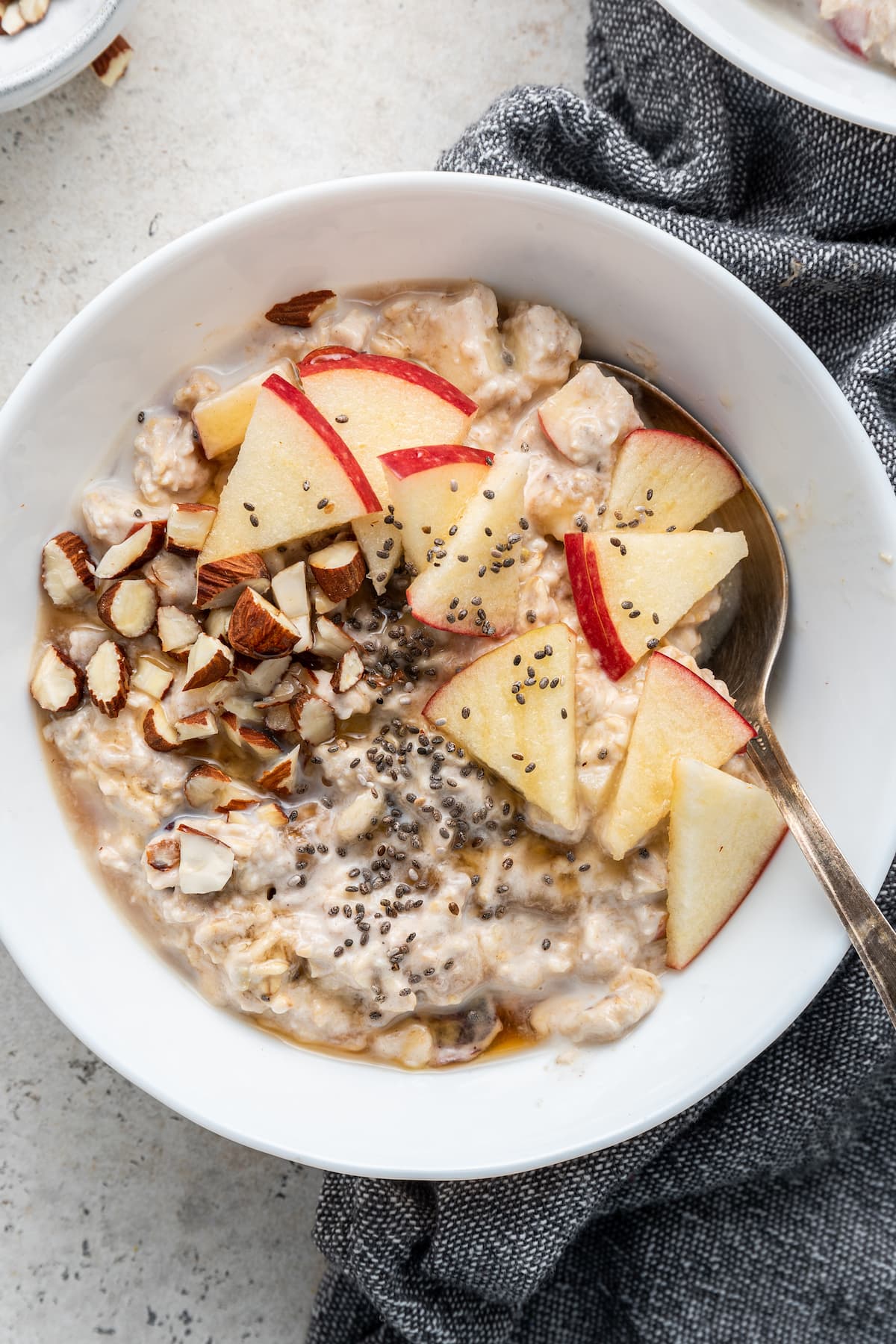 Bircher Muesli in a white bowl with a spoon.