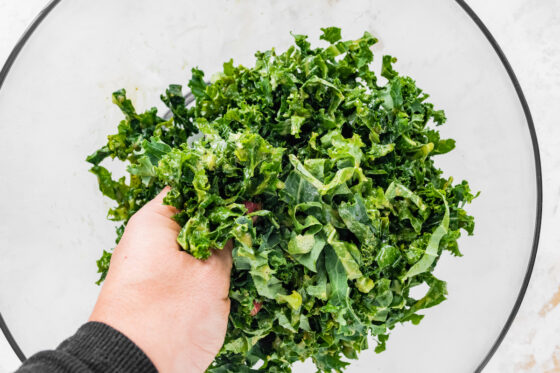 Massaging dressing into kale.