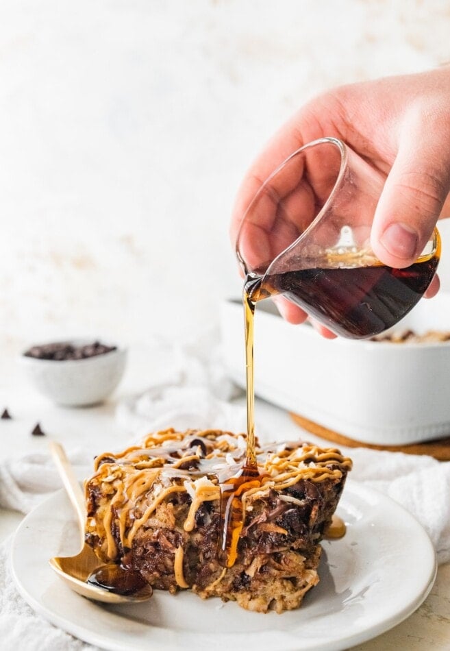Pouring maple syrup on a serving of lactation baked oatmeal.
