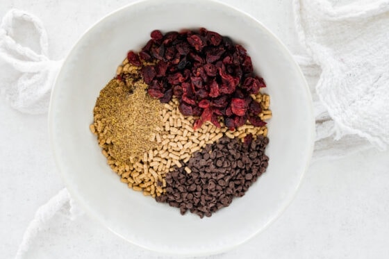 Smart bran cereal, flaxseed, dried cranberries and mini chocolate chips in a bowl.