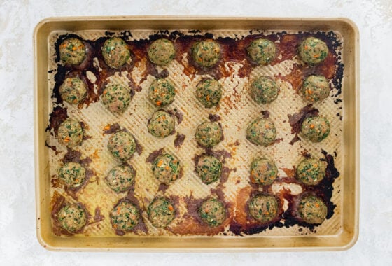 Baked spinach turkey meatballs on a baking sheet.