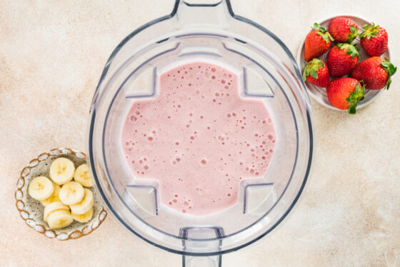 A strawberry banana protein smoothie in a high-powered blender.