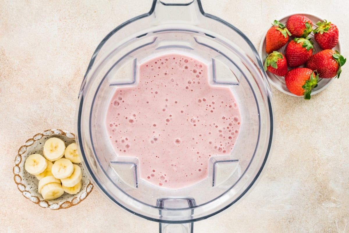 A strawberry banana protein smoothie in a high-powered blender.