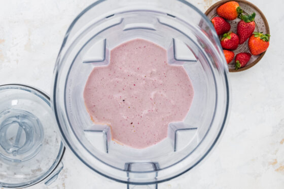 Strawberry protein shake in a high-powered blender.