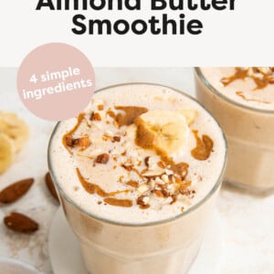 Banana almond butter smoothies in glasses, topped with almonds, almond butter and banana slices.