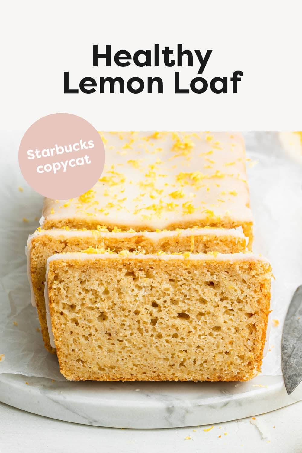 A lemon loaf topped with a lemon glaze and lemon zest. The loaf is cut so you can see the inside of the loaf.