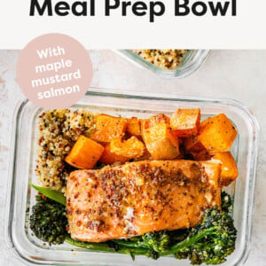 One glass storage container with a bed of quinoa topped with roasted sweet potatoes and broccolini and mustard maple salmon.