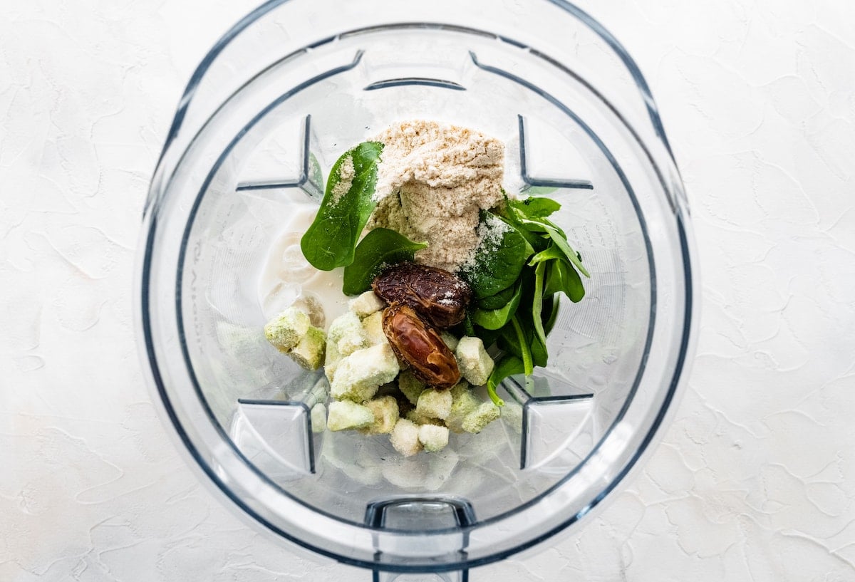 Ingredients for avocado smoothie in blender.