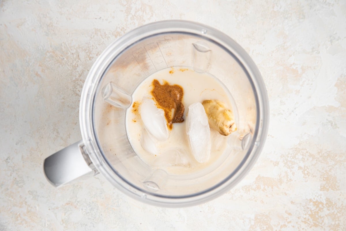 Ingredients for banana almond butter smoothie in blender.