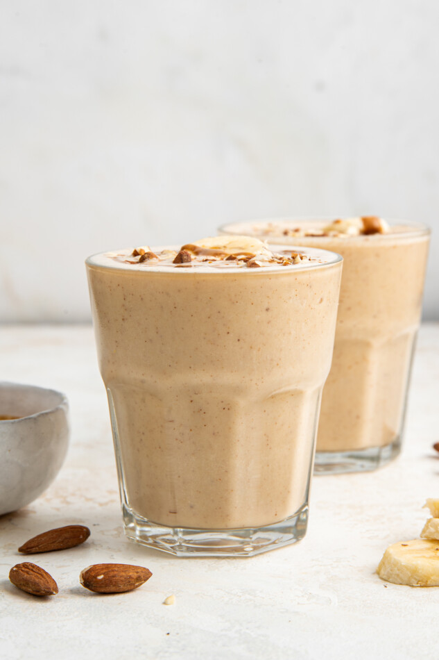 Two glasses filled with banana almond butter smoothies.