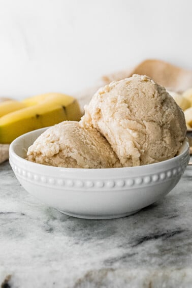 White bowl with two scoops of banana frozen yogurt.