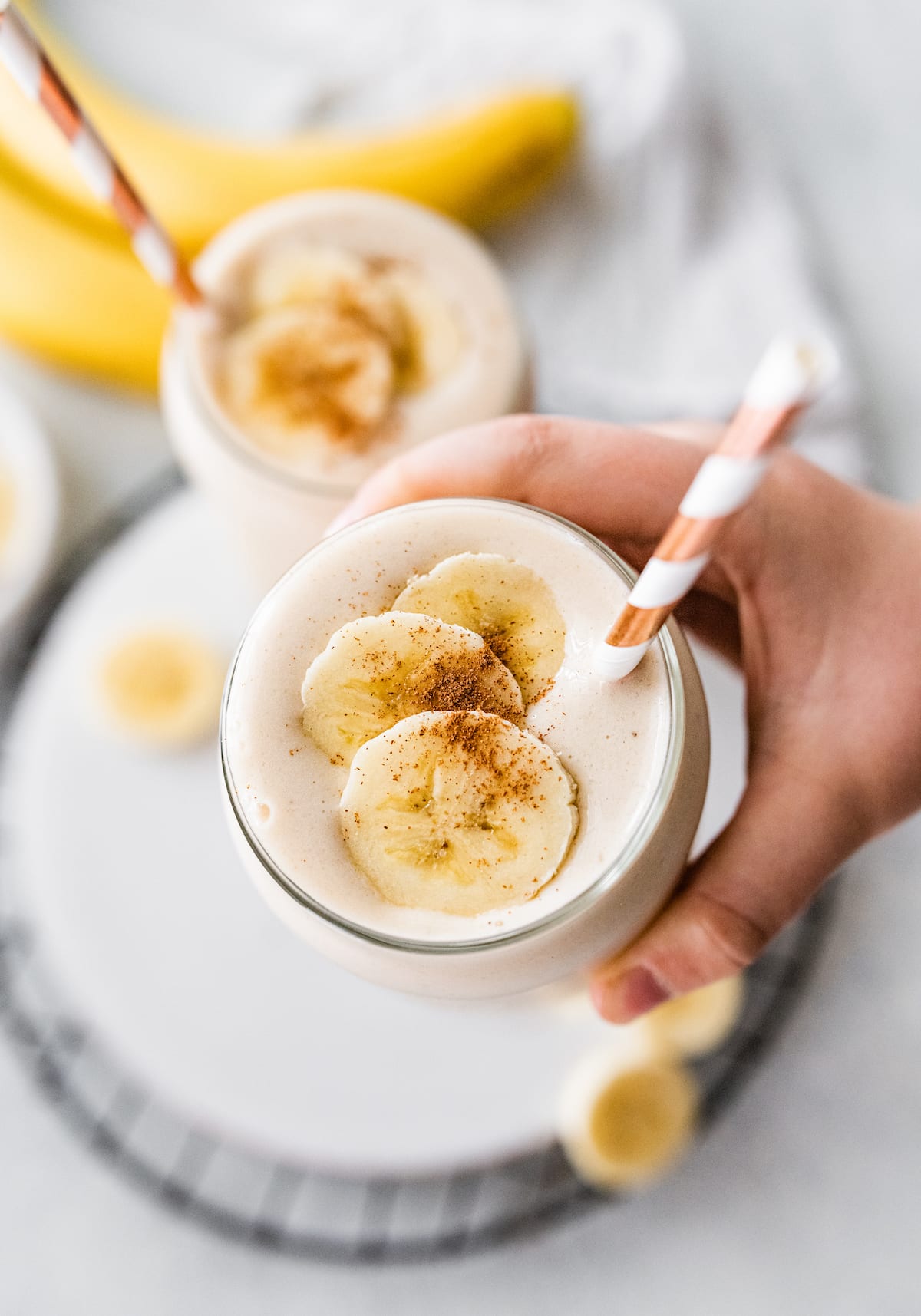 Woman's hand holding a banana smoothie.