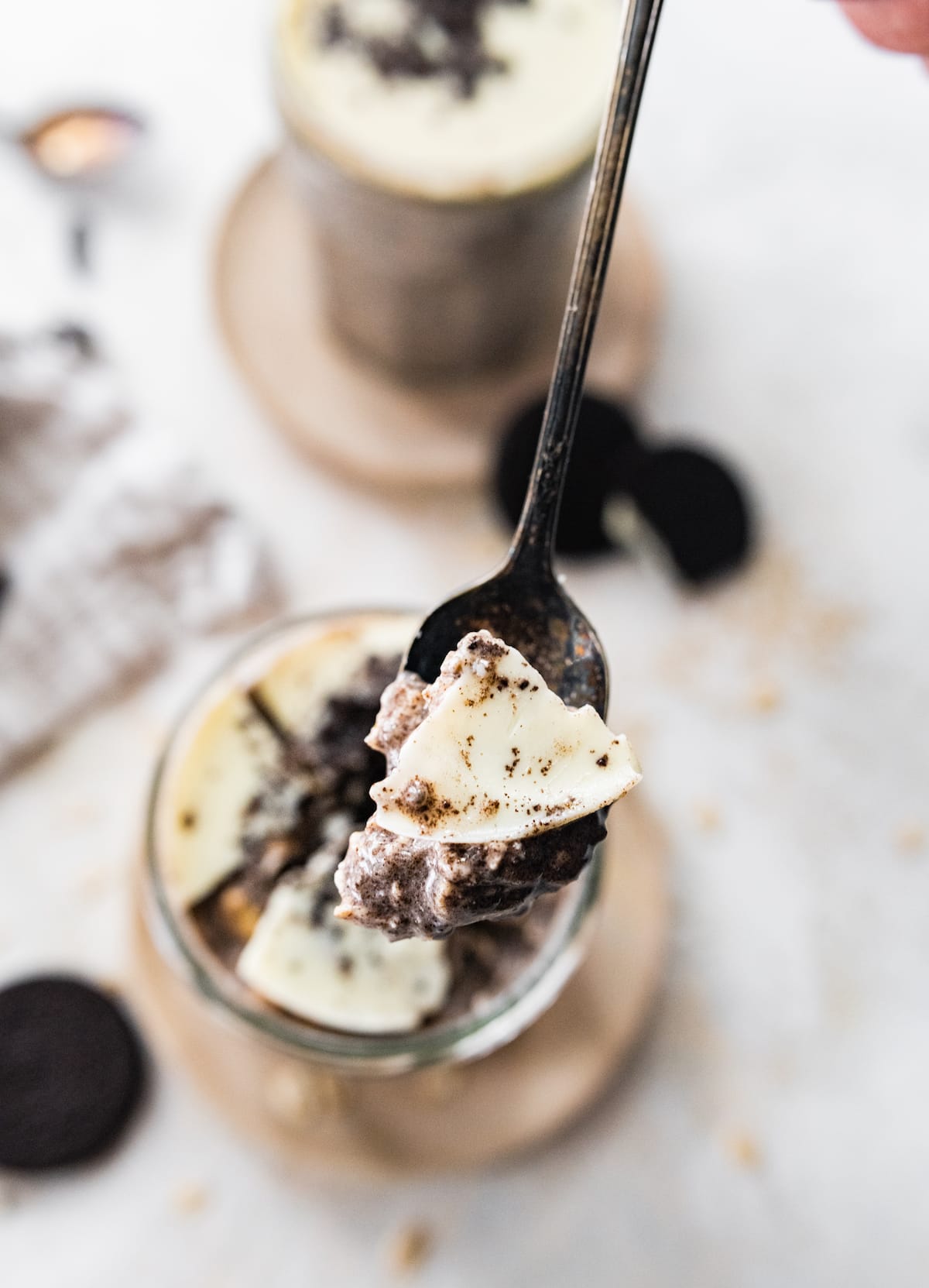 Spoonful of cookies and cream overnight oats with magic shell topping.