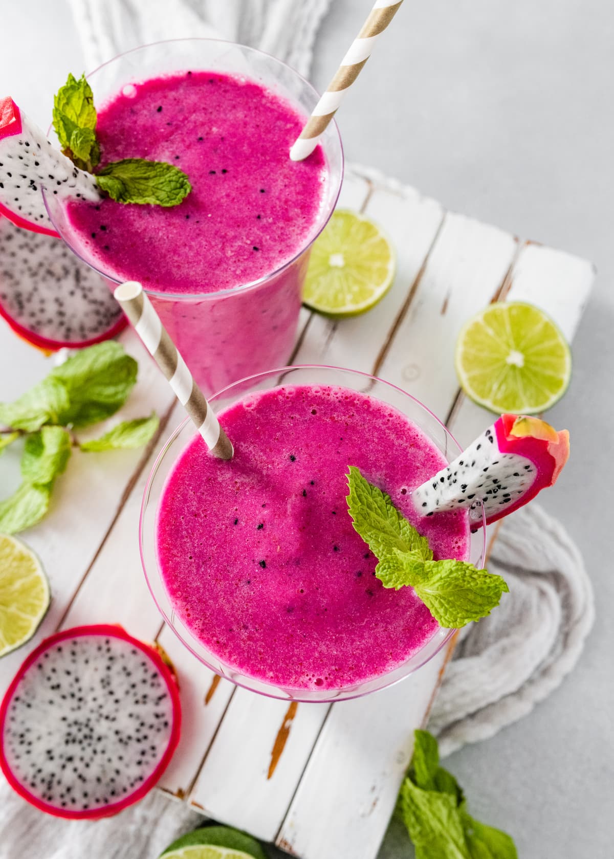 The top of two dragon fruit smoothies in glasses with straws.