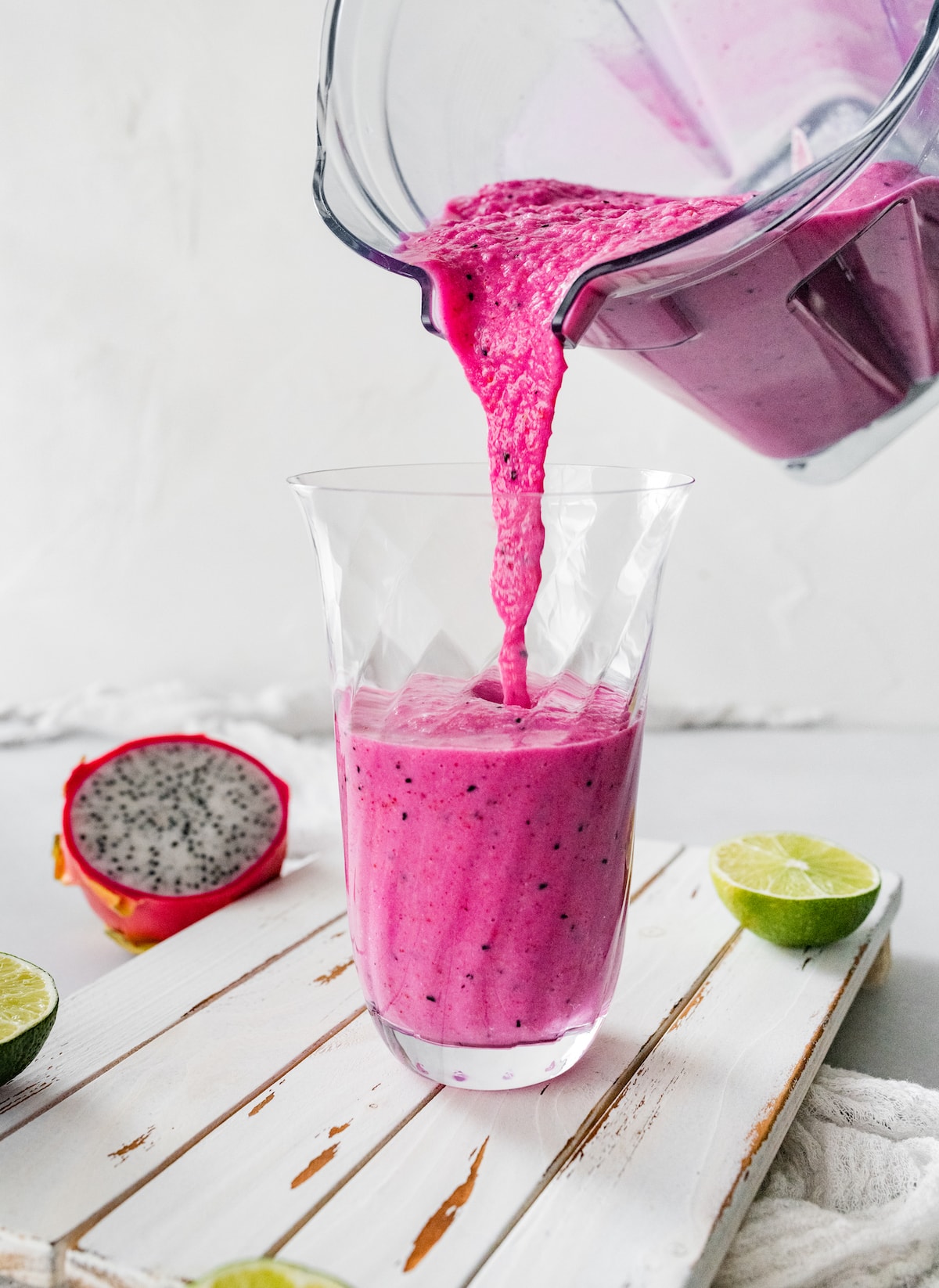 Dragon fruit smoothie being poured into a glass.