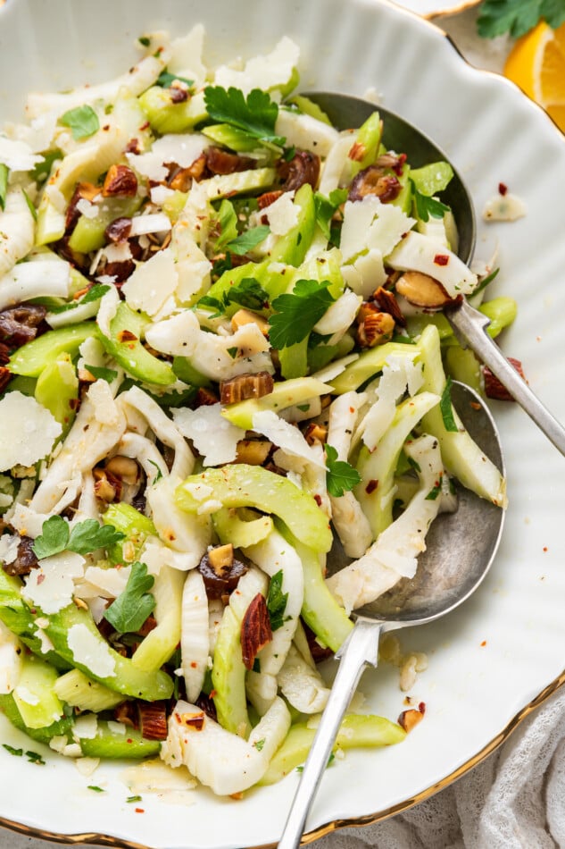 Fennel and Celery Salad with Dates and Shaved Parmesan // A bright and fresh salad that you can add to any meal! Close up photo of fennel and celery salad with serving spoons.
