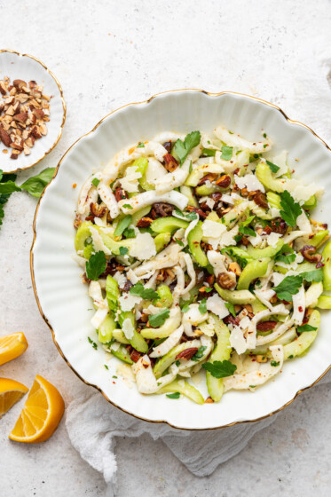 Close up image of fennel and celery salad in white serving bowl.