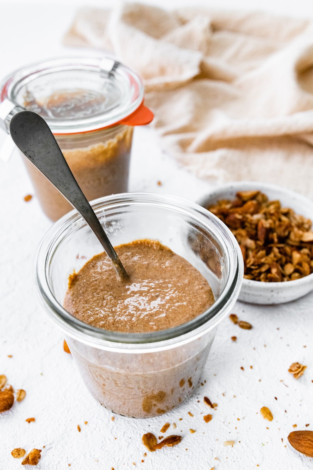 Granola butter in a weck jar with a spoon in it.