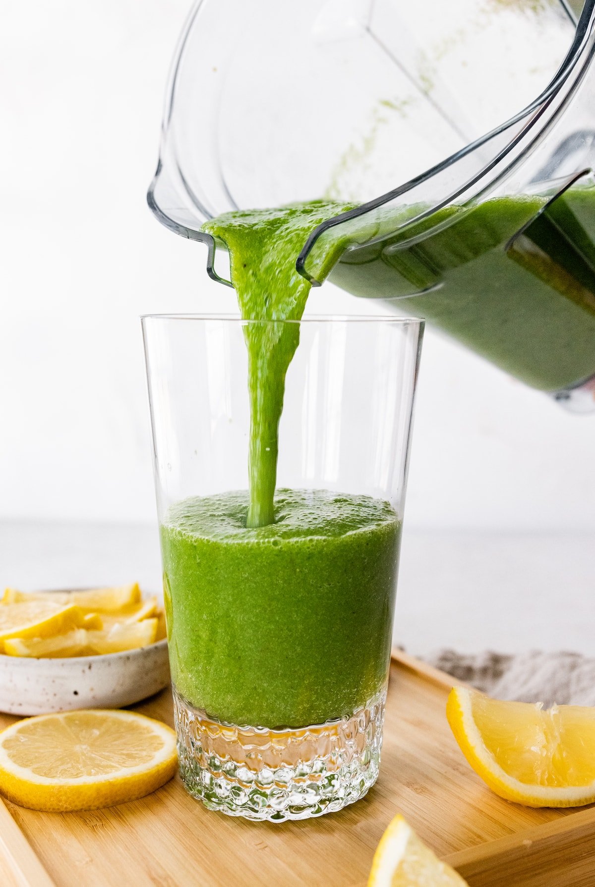 Green lemonade smoothie being poured into a glass.