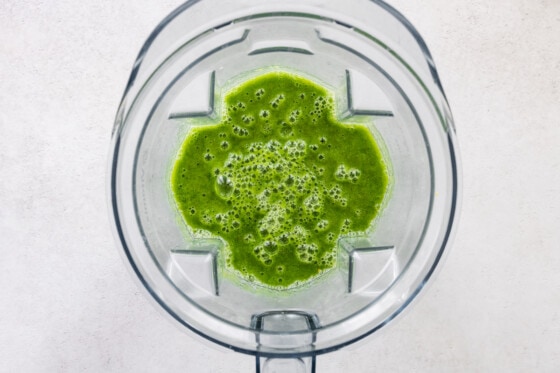 Green lemonade smoothie blended in a blender.