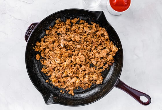 Ground turkey cooking in a cast iron skillet.