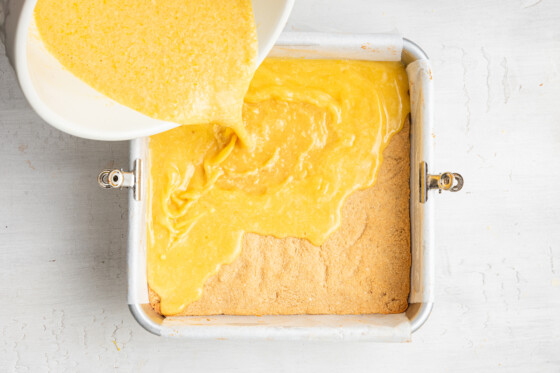 Lemon filling being poured into pan with crust.