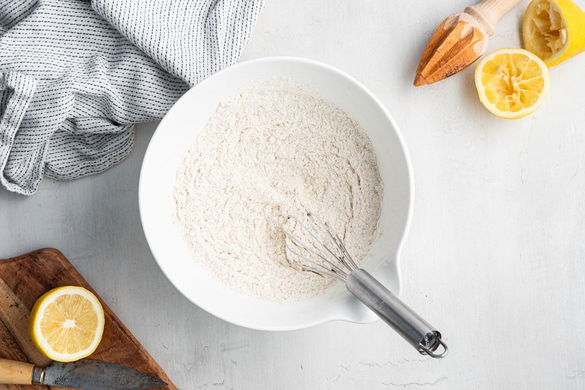 The dry ingredients for the lemon loaf combined in a white mixing bowl.