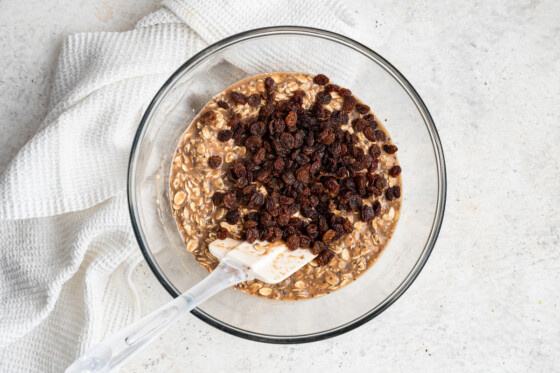 Raisins added to bowl of oatmeal raisin protein bars mixture.