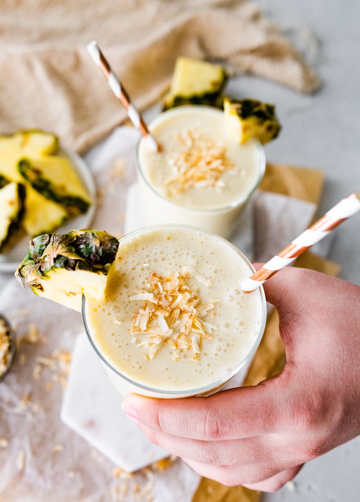 Woman's hand holding a pineapple smoothie.