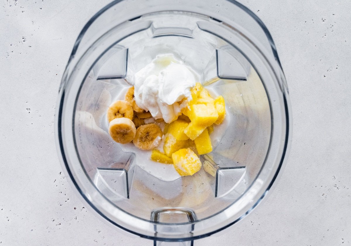 Pineapple smoothie ingredients in a blender.