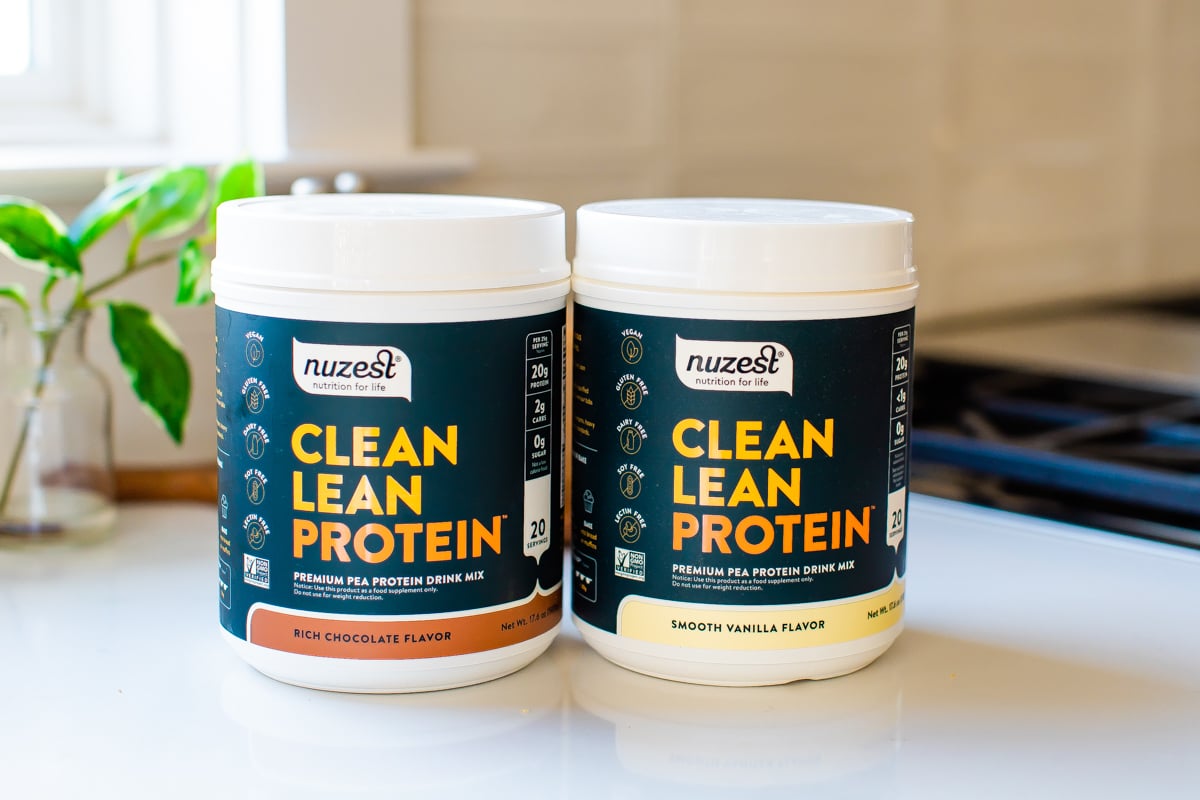 Chocolate and vanilla containers of Nuzest protein powder.