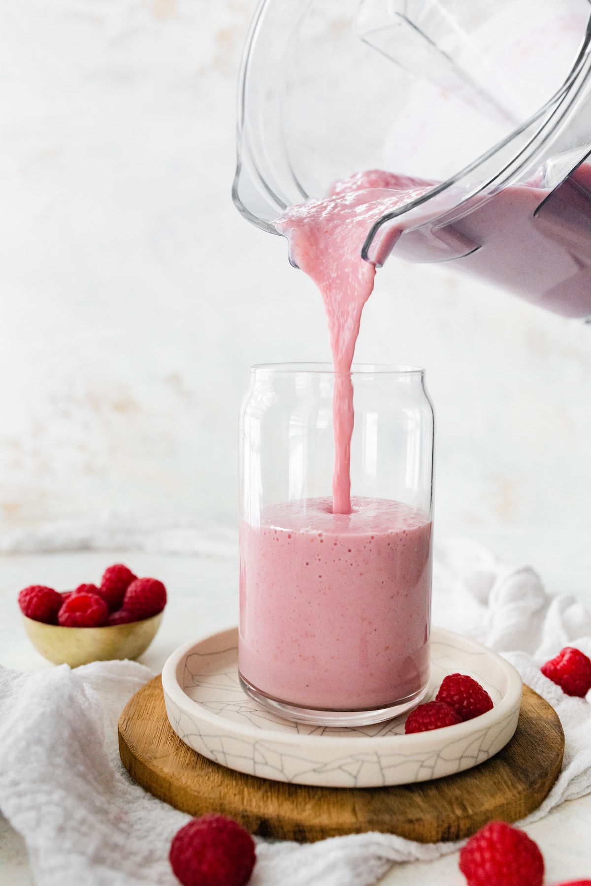 Raspberry smoothie being pored into glass.