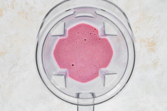 Blended raspberry smoothie in blender.