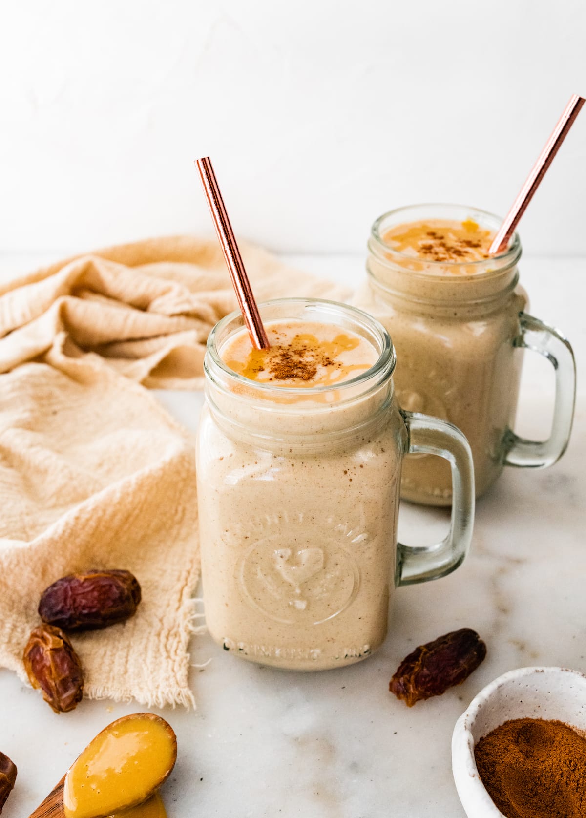 Two tahini smoothies with straws.