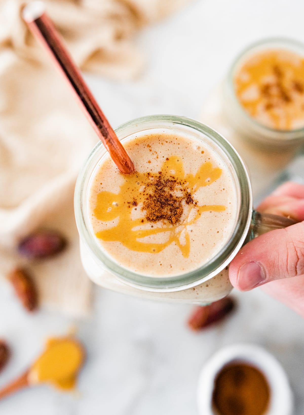 Woman's hand holding tahini smoothie.