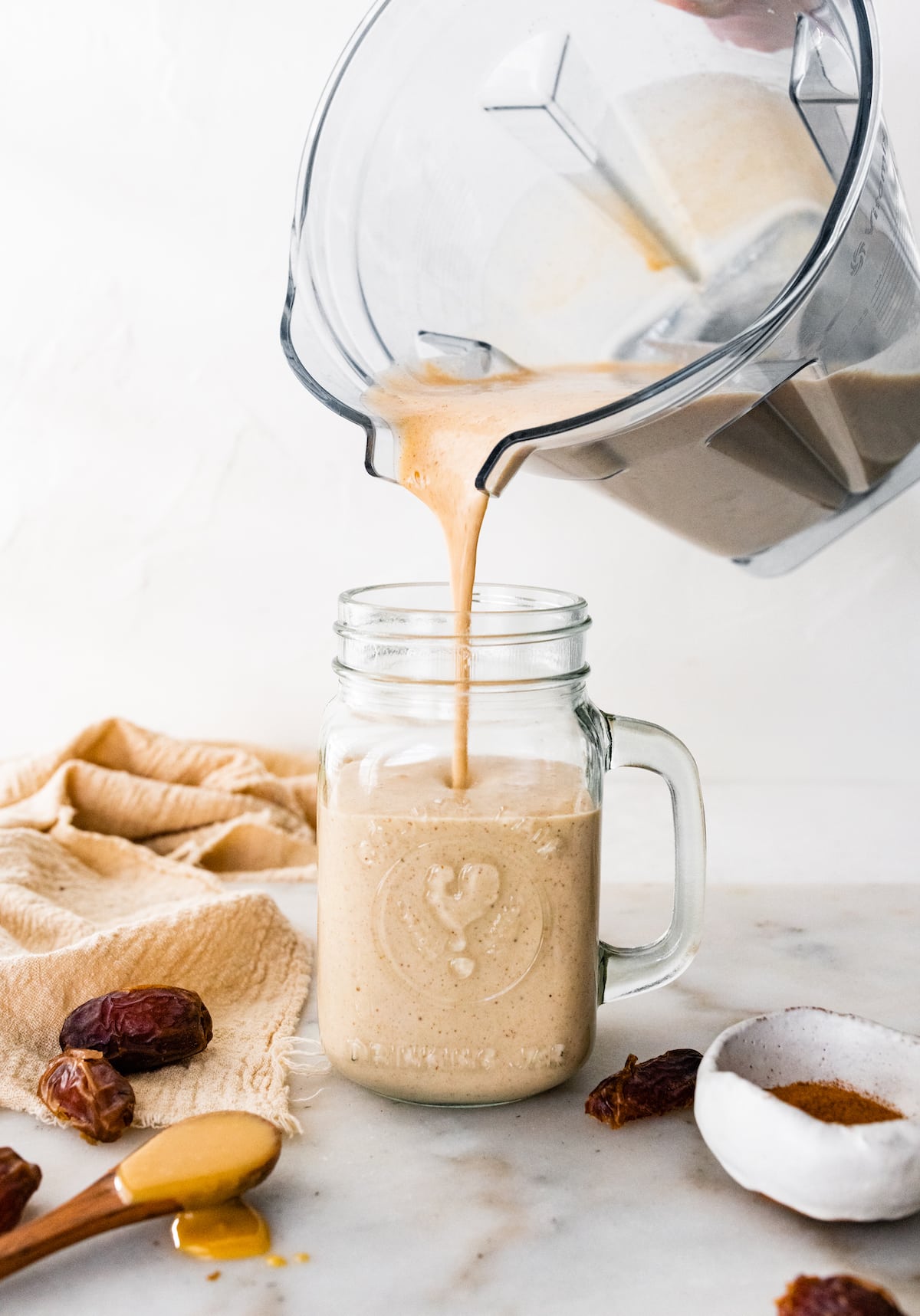 Tahini smoothie being poured into glass.