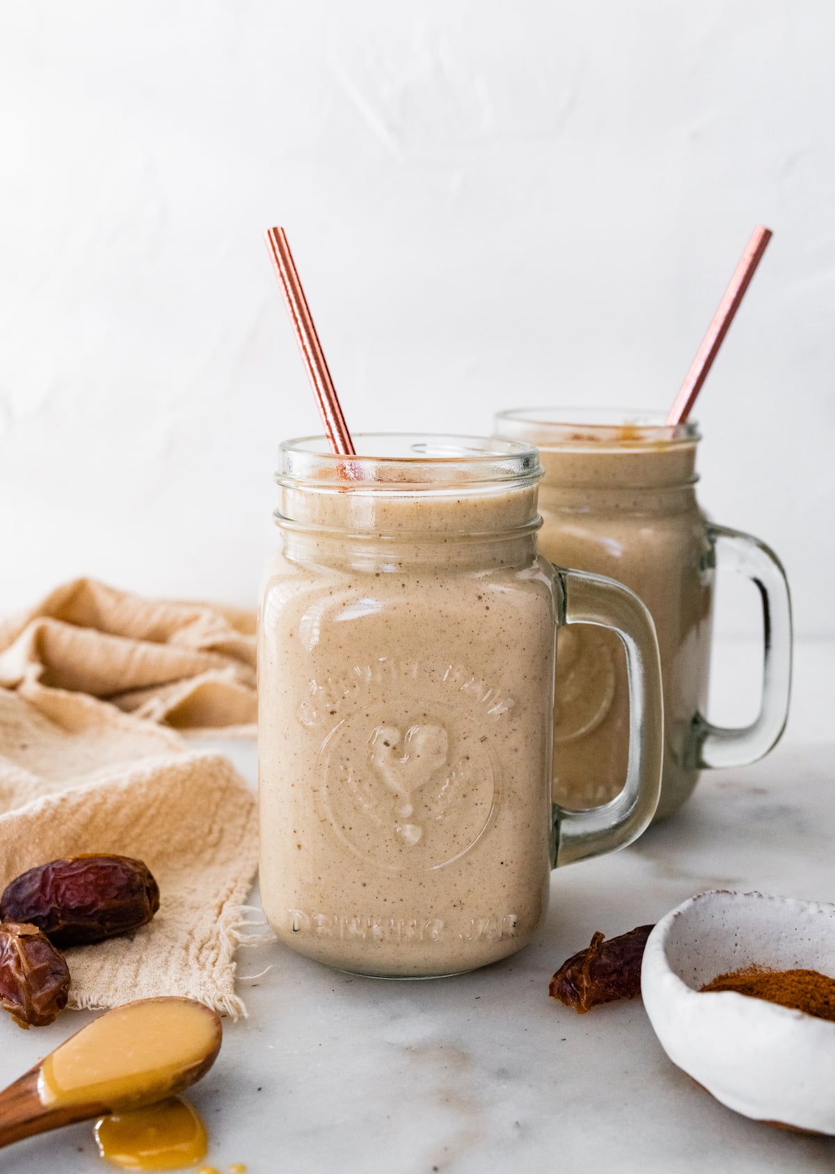 Two tahini smoothies with straws.