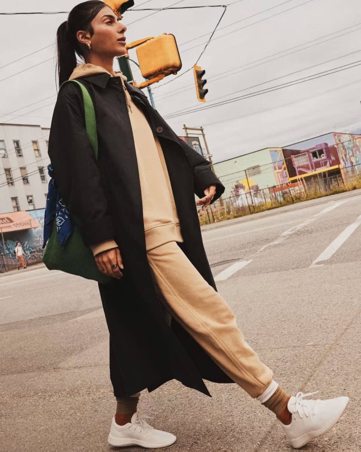 Woman walking on street with Allbird wool runner sneakers.