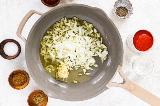 Onions and garlic being sautéed in a skillet.