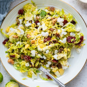 A white plate with a serving of the Brussels sprout chopped salad.