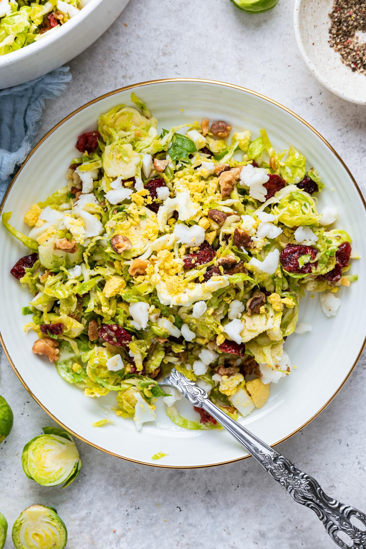 A white plate with a serving of the Brussels sprout chopped salad.
